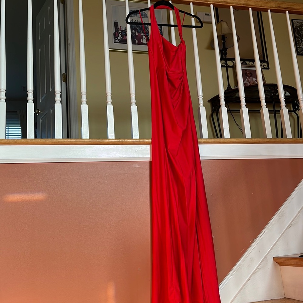 Red floor length, over the shoulder, low back gown with high thigh slit